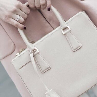 A woman holding onto the handle of her purse